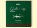 A tin of sea bass a la bilbaina or Bilbao style in green card packaging against a wood background. The packaging has Alalunga written in silver lettering above a white illustration of a sea bass, and a red strip along the bottom.