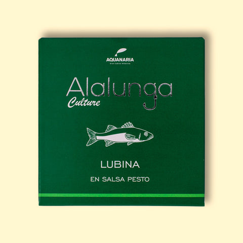 A tin of sea bass in pesto in green card packaging against a pale yellow background. The packaging has Alalunga written in silver lettering above a white illustration of a sea bass, and a green strip along the bottom.