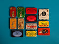 A selection of colourfully-packaged tinned sardines, tuna, mackerel and mussels against a blue background.