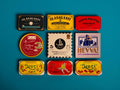 A selection of colourfully-packaged tinned sardines, tuna belly, octopus and mussels against a blue background.