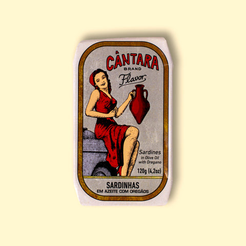 A tin of sardines with a paper wrap depicting a woman in a red dress holding an amphora of olive oil. The tin is against a wood background