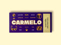 Carmelo seafood packaging on a pale yellow surface. The design looks very premium and has golden illustrations of a book, a pair of sunglasses, a suitcase and a wine glass.