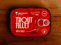Trout fillet with chilli in extra virgin olive oil, packaged in a red tin with black borders with an illustration of a chilli pepper.