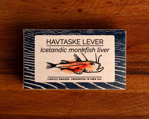 A rectangular tin of monkfish liver in white and blue packaging, featuring an illustration of a monkfish with the text "lightly smoked" below.