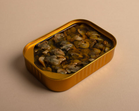 Limfjord cockles in rapeseed oil, presented in an open golden tin.