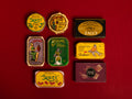 A selection of colourfully-packaged tinned sardines, mackerel, tuna, squid and sardine and mackerel pâtés against a red background.