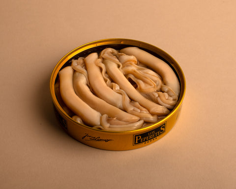 An open circular golden tin with the Los Peperetes label, containing razor clams in brine, against a pale backdrop.