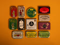 A selection of colourfully-packaged tinned sardines, mackerel, tuna, squid and mussels against a yellow background.