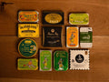 A selection of colourfully-packaged tinned mussels, tuna belly, tuna, sardines and squid against a wood background.