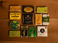 A selection of colourfully-packaged tinned mussels, tuna belly, tuna, sardines and squid against a wood background.