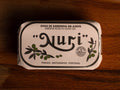 A tin of sardine roe in olive oil, in white and silver packaging, with illustrations of olive branches beneath the Nuri logo.