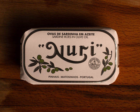 A tin of sardine roe in olive oil, in white and silver packaging, with illustrations of olive branches beneath the Nuri logo.