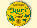 A round tin of sardine pate in a yellow paper wrap. Nuri is written in green lettering above some drawings of olives.