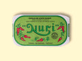 A tin of spicy mackerel in a green paper wrap with a white border. Nuri is written in green lettering above some red chilli peppers.