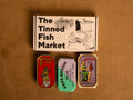 A selection box containing Berthe olive oil sardines, Papa Anzois octopus and Cantara stuffed squid.