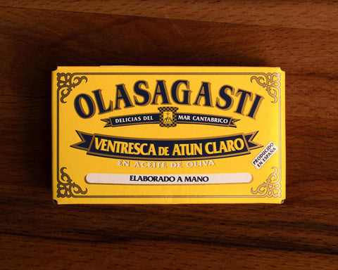 A tin of yellowfin tuna belly in a rectangular yellow box with blue lettering and a gold border.