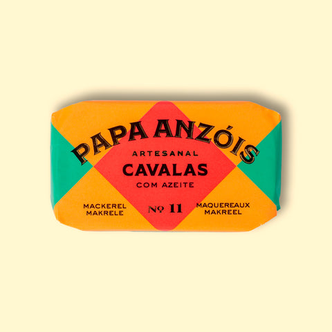 A tin of mackerel in olive oil from Papa Anzois, inside a brightly coloured orange, red and green packaging.