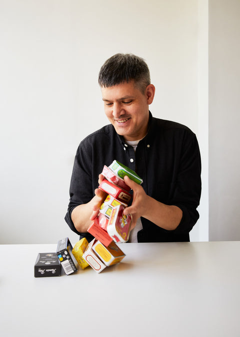 The Tinned Fish Market owner Patrick Martinez, holding an array of tinned fish against a white background.