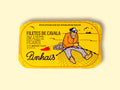 Mackerel fillets in a yellow paper wrap. There is a drawing of a red chilli pepper and a fisherman mending a fishing net on the front.