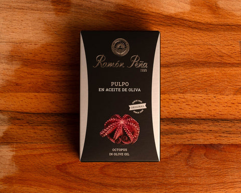 A tin of Ramon Pena octopus in olive oil, in black card packaging featuring an illustration of octopus tentacles on the front.
