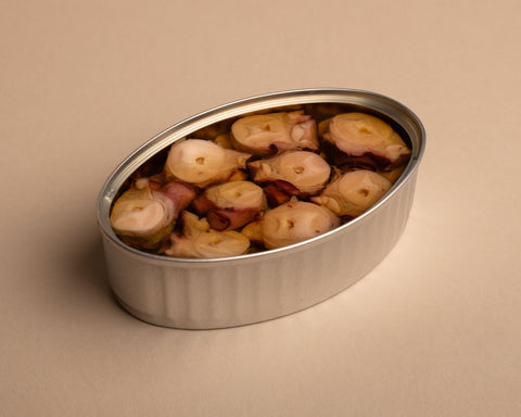 An open silver tin containing nine pieces of squid neatly arranged, set against a pale backdrop.