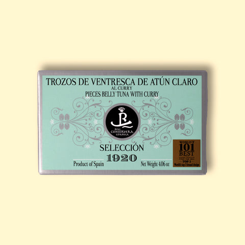 A rectangular tin of tuna belly with curry in mint green packaging with grey borders, set against a wooden backdrop.