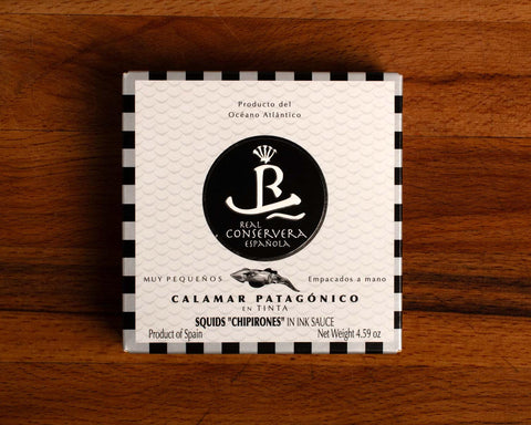 Squid in black and white card packaging with silver and black borders, featuring a central illustration of a squid.
