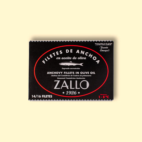 A tin of Cantabrian anchovies in black and red packaging against a light wood background.