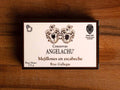 A tin of mussels in rectangular white card packaging with a black border with Angelachu written below two coats of arms
