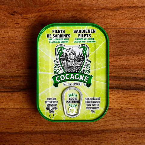 A lime-green tin with an image of the game tallow-stick on the front. Cocagne is written in white lettering against a green background.