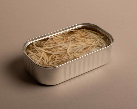 An open tin of baby eels in a clear oil, in a silver-coloured tin.