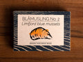 A rectangular box with a blue border and an image of a mussel shell painted orange on the front.