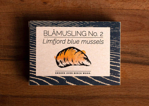 A rectangular box with a blue border and an image of a mussel shell painted orange on the front.