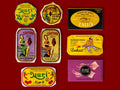 A selection of colourfully-packaged tinned sardines, mackerel, tuna, squid and sardine and mackerel pâtés against a red background.