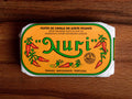 Mackerel in spicy olive oil in an orange paper wrap with a green and white border, and Nuri written in green lettering above some red chilli peppers