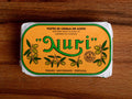 Mackerel fillets in an orange wrap with a white and green border. Nuri is written in green lettering above some small olive branches.