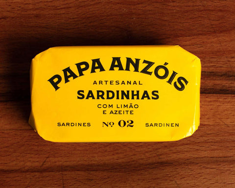 Sardines with olive oil and lemon in vivid yellow packaging, featuring Papa Anzóis displayed at the top.