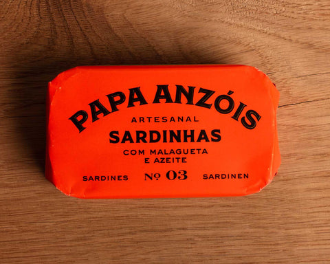 A tin of sardines with chilli and olive oil in bright red packaging, featuring the Papa Anzois brand name at the top.