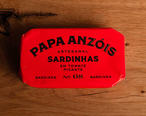 A tin of sardines in spicy tomato sauce in bright red packaging, with Papa Anzóis displayed at the top.
