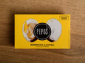 A tin of cockles in yellow card packaging with an image of an open cockle and the round Pepus logo on the front