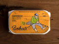 Tinned sardines in an orange paper wrap with an image of a fisherman mending a fishing net by the Pinhais logo.