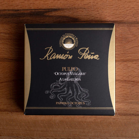 Tinned paprika octopus in black and gold packaging. Ramón Peña is written in raised gold lettering above a silver grey image of an octopus on the front of the packaging.
