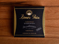 Sardines in olive oil in black and gold card packaging. Ramón Peña is written in raised gold lettering above a silver-grey image of a sardine.