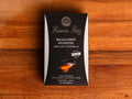 A tin of spicy mussels in a rectangular silver and black box with nautical cartoons on the silver border.