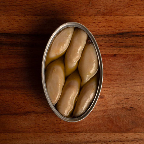 Open tin of squid in olive oil, there are six small squids inside the tin, they look tender and delicious.
