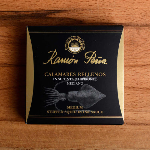 A tin of stuffed squid in black and gold packaging. Ramón Peña is written in gold lettering above a silver-grey image of a squid