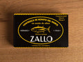 A rectangular box with light orange lettering and an image of a tuna, with Zallo written in white beneath it