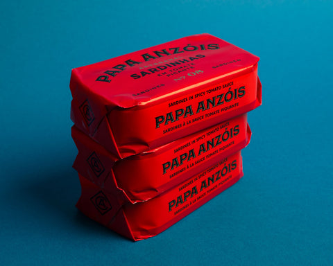 a stack of sardine tins with bright red paper wrapings