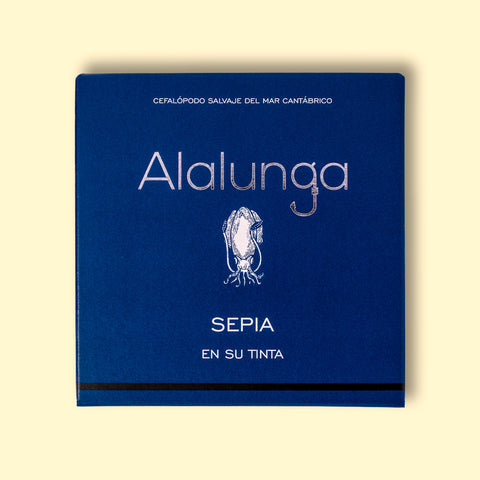 A tin of cuttlefish in ink in square-shaped blue card packaging  against a pale yellow background. The packaging has Alalunga written in silver lettering above a white illustration of a cuttlefish.