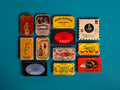 A selection of colourfully-packaged tinned sardines, tuna, mackerel and mussels against a blue background.